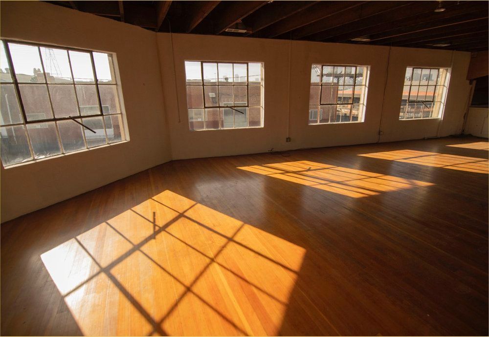 An empty room with lots of windows and a wooden floor