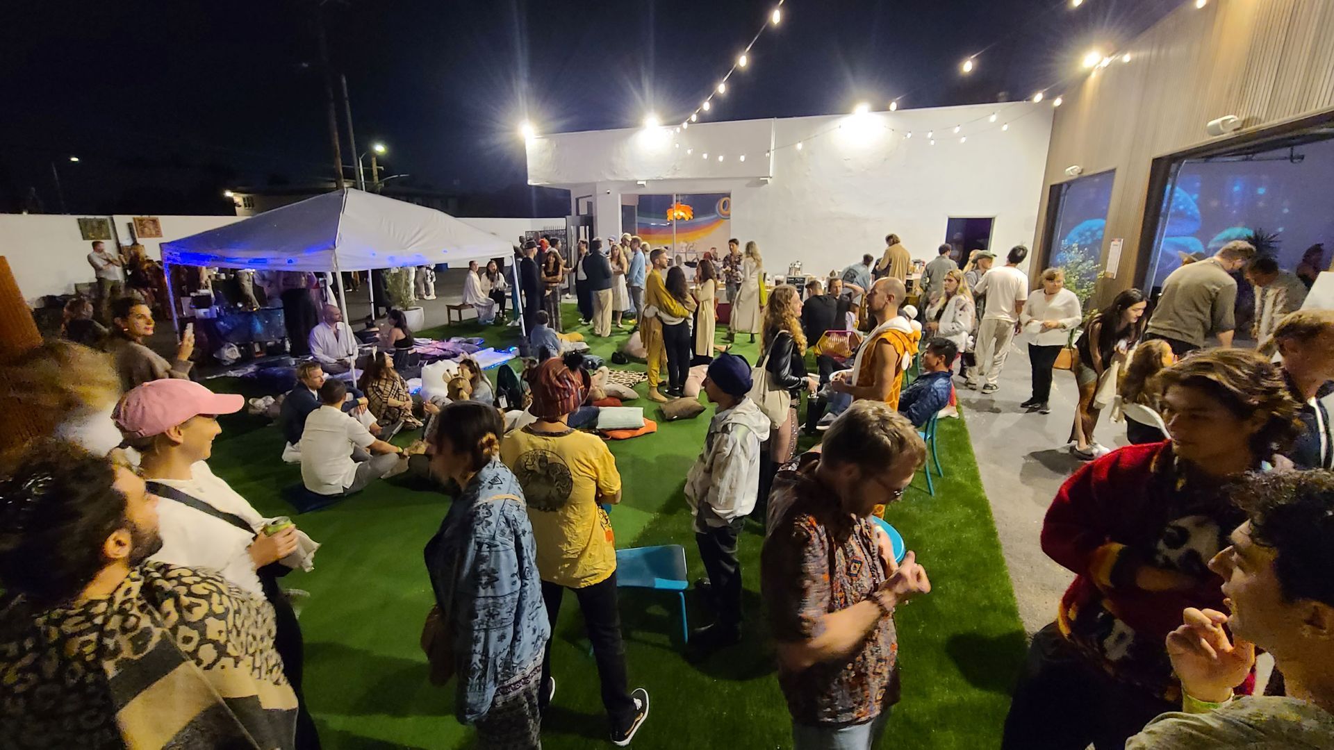 A large group of people are gathered outside at night.