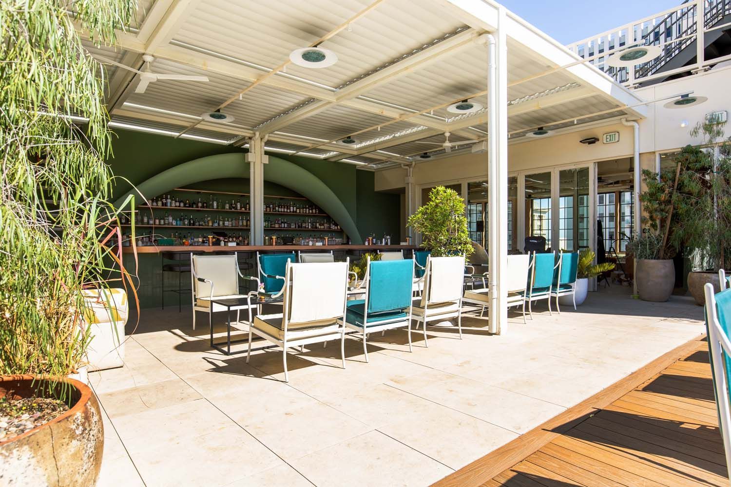 There are many chairs and tables outside of a restaurant.