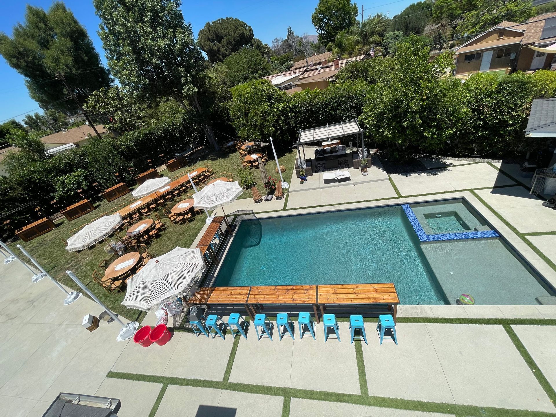 An aerial view of a large swimming pool surrounded by chairs and umbrellas