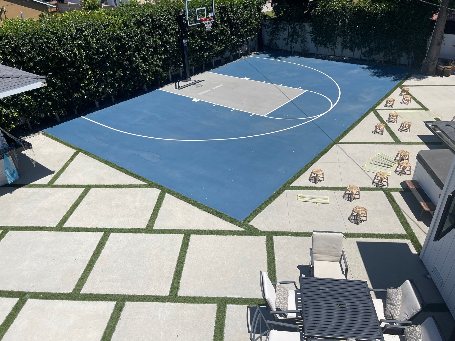 A basketball court in a backyard with a table and chairs