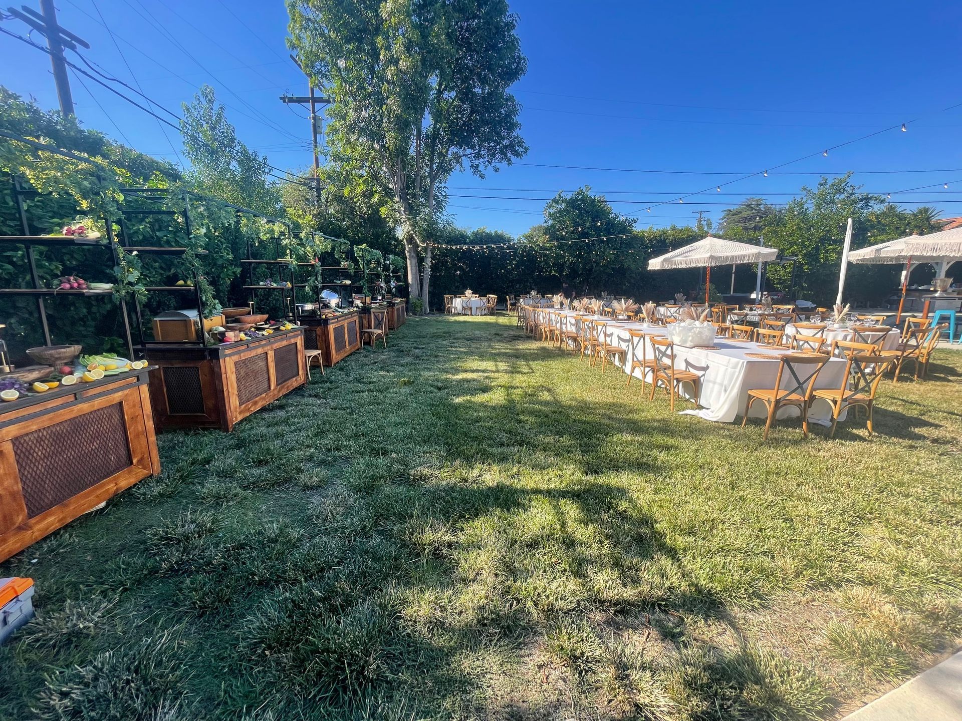 A large grassy field with tables and chairs set up for a party.