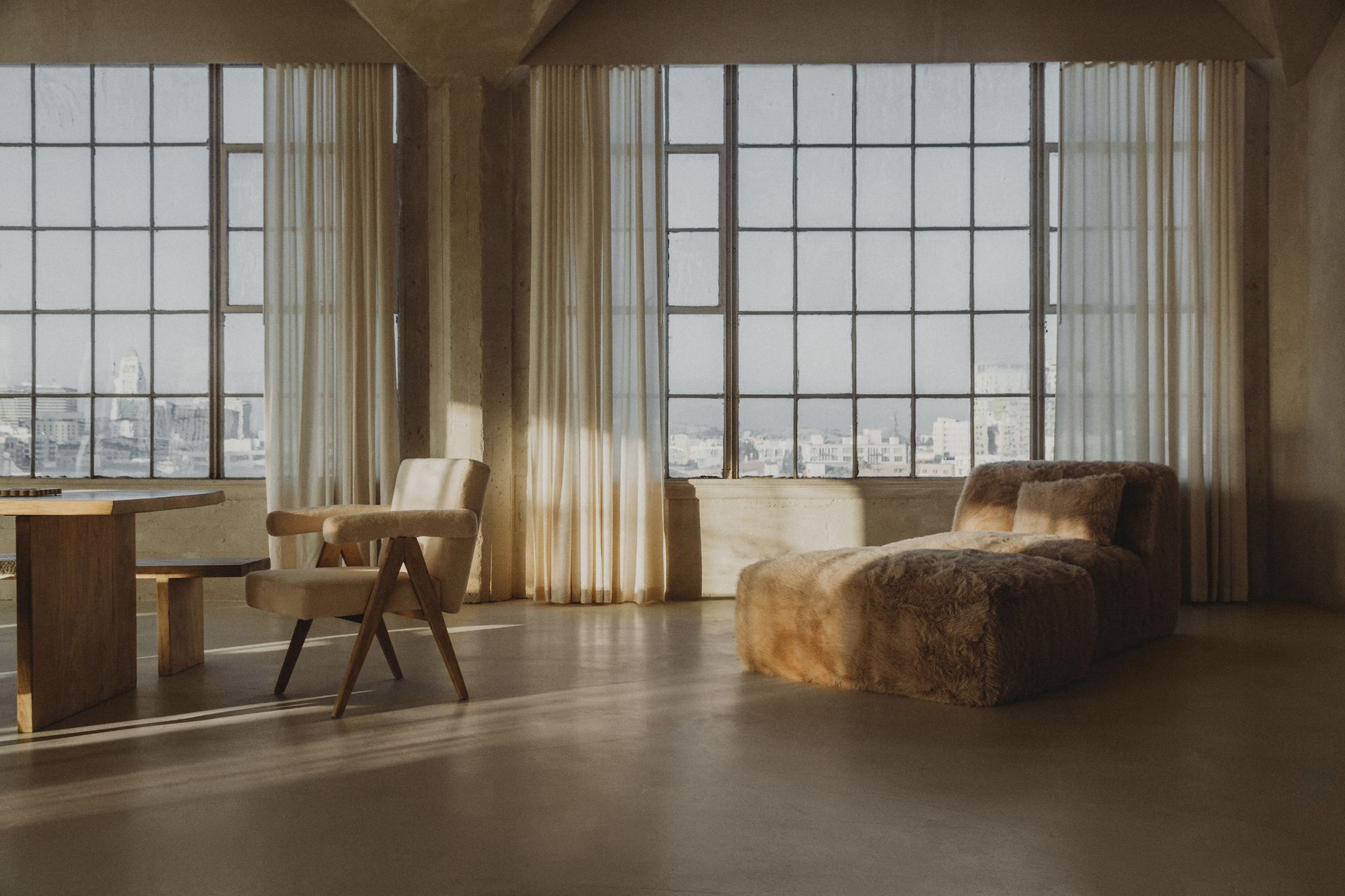A living room with a lot of windows and furniture.