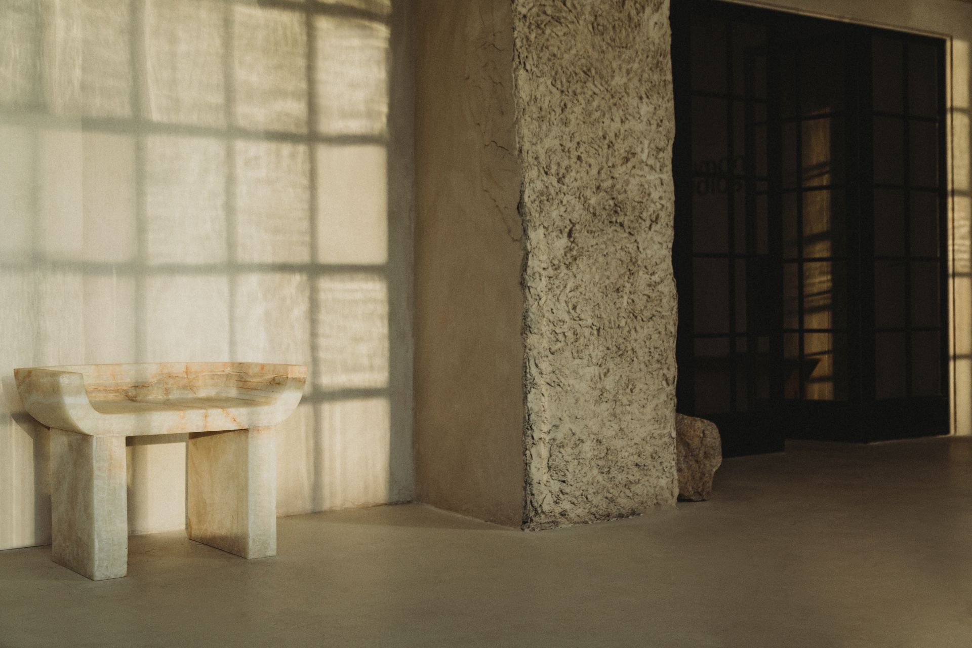 A room with a table and a pillar in the corner.