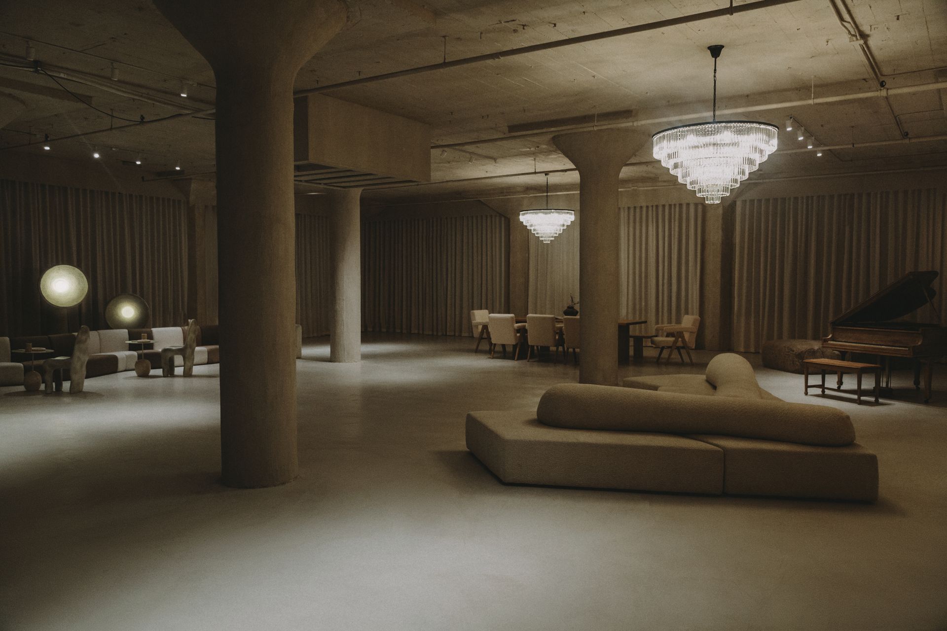 A large room with a lot of furniture and a chandelier hanging from the ceiling.