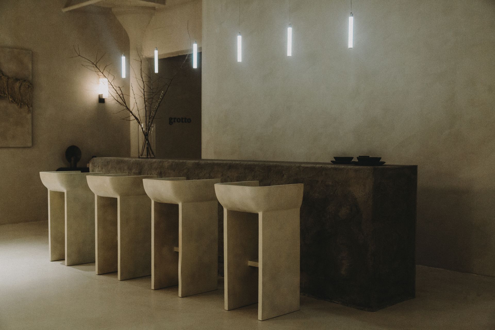 A row of stools are lined up in front of a counter in a room.
