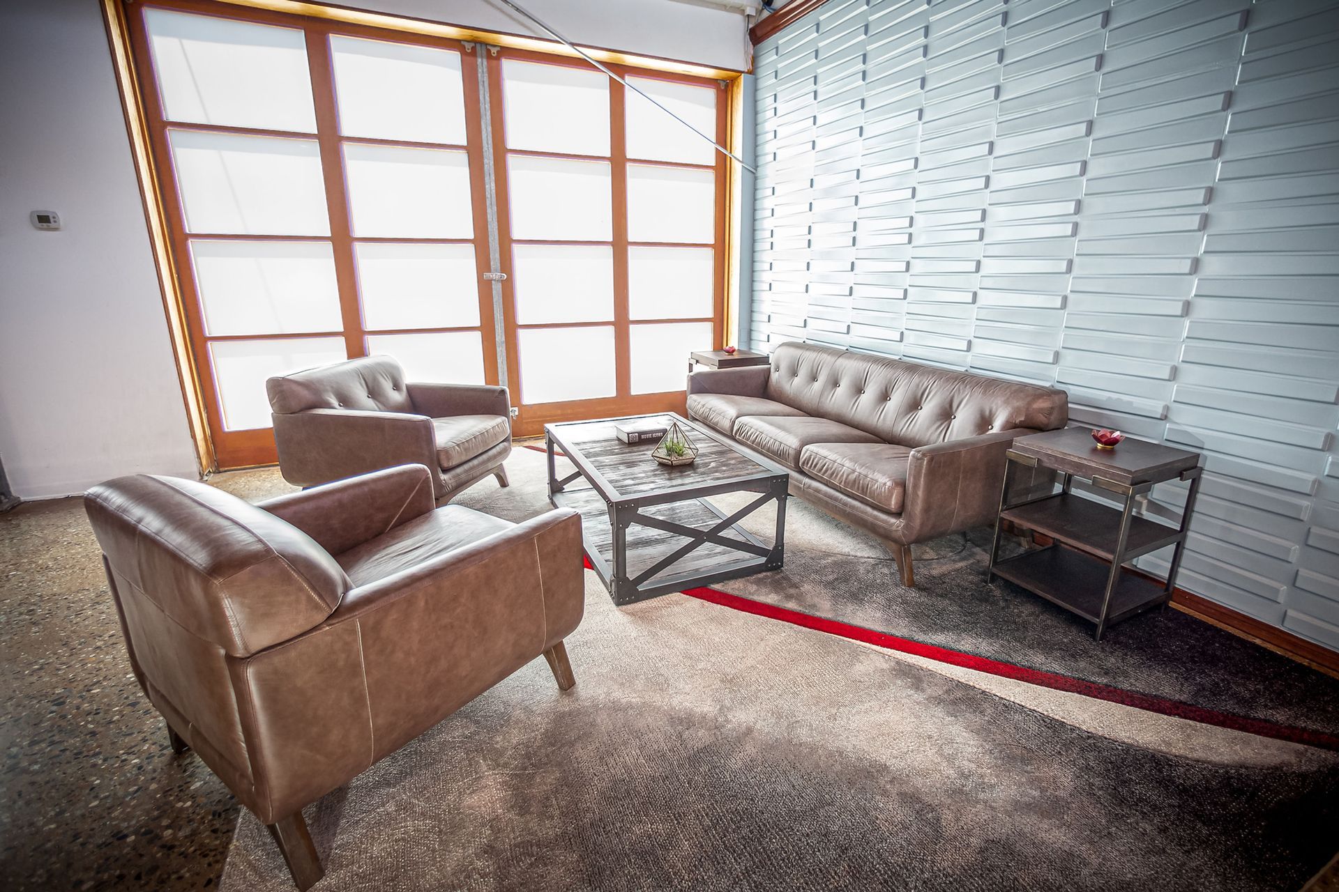 A living room with a couch , chairs , and a coffee table.