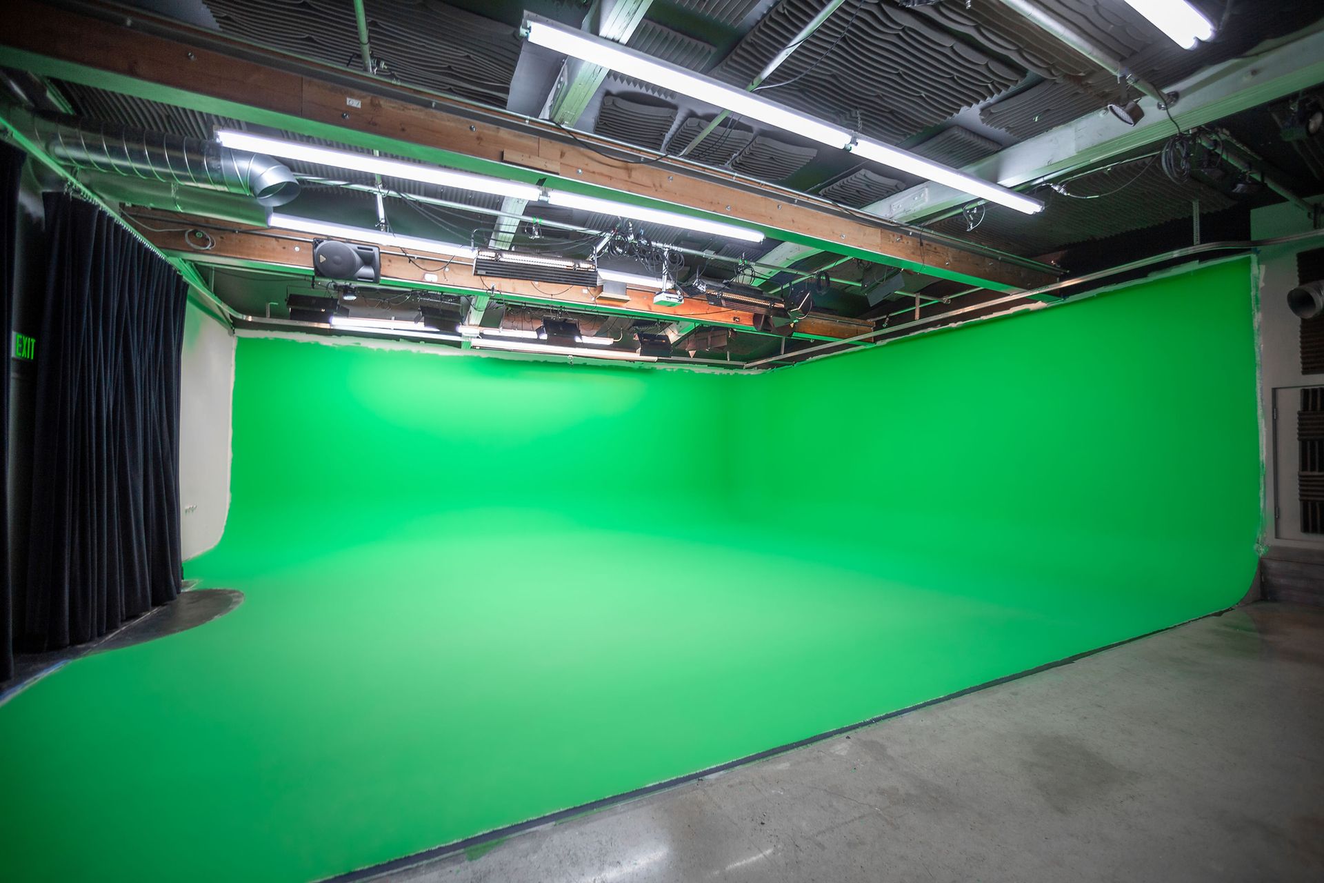 There is a green screen in the middle of the room.