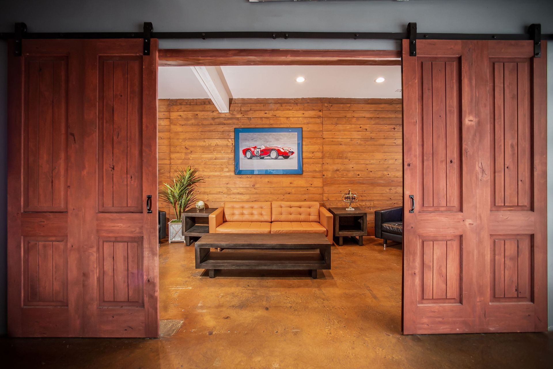 A living room with a couch and a table between two sliding barn doors.
