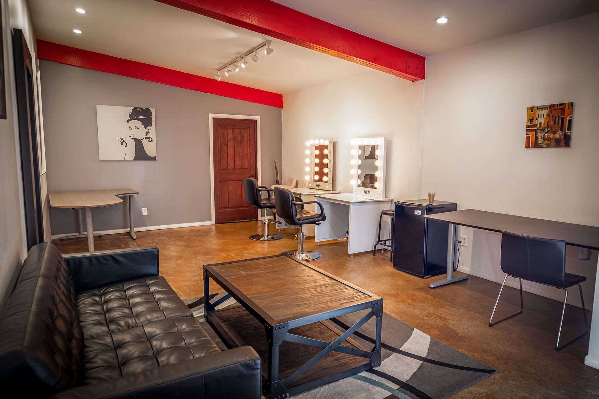 A living room with a couch , table , chairs and mirrors.