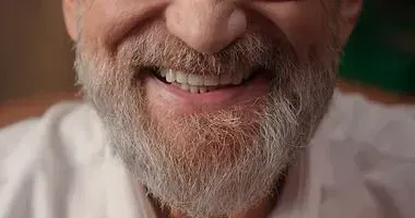Close-up of a smiling bearded man with his removable Implant overdentures.