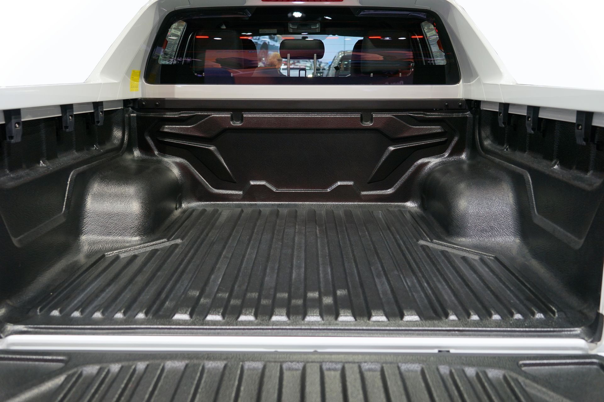 The back of a pickup truck with a rubber bed liner.