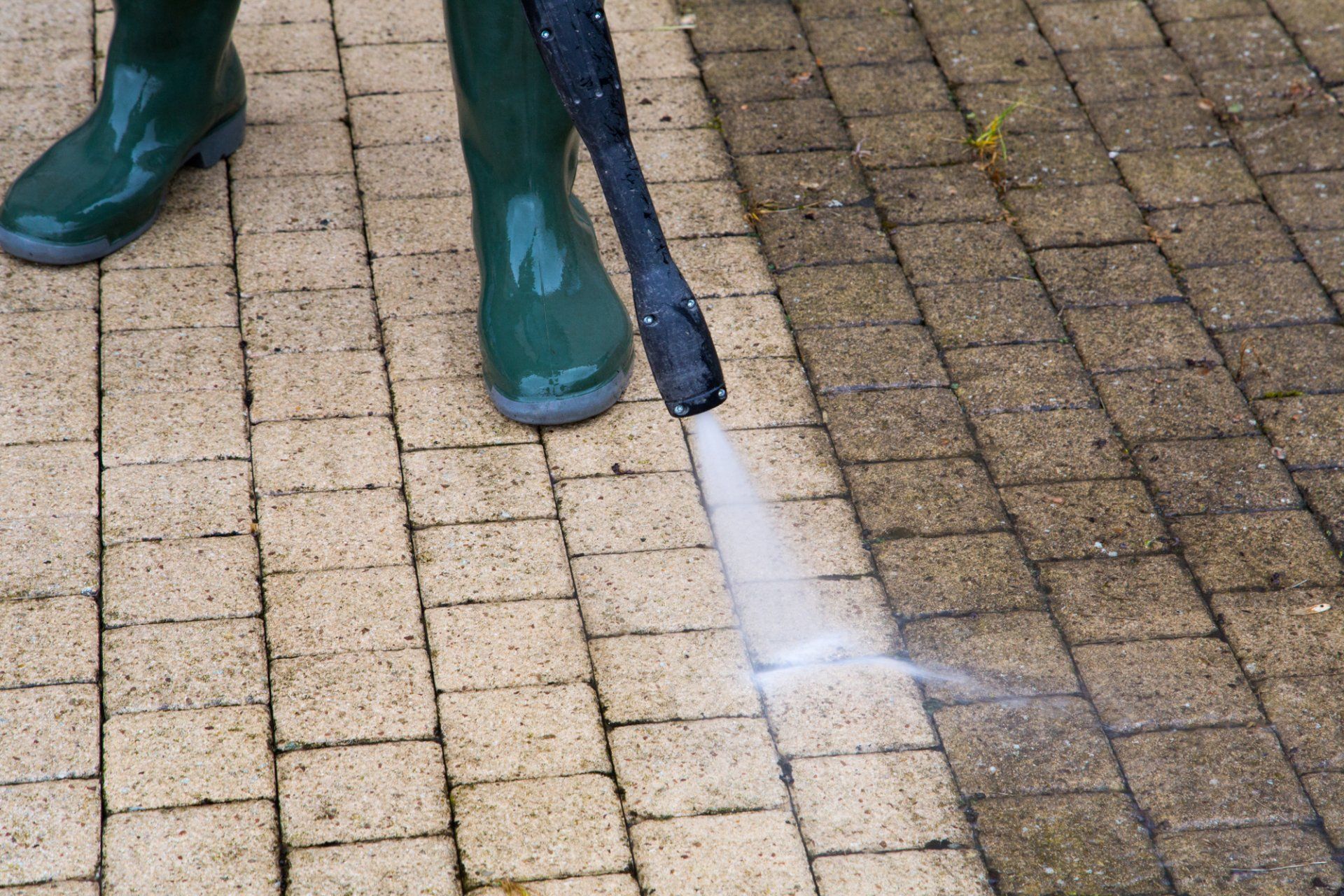 Quick Solutions Cleaning team member pressure washing a brick floor in Rhode Island