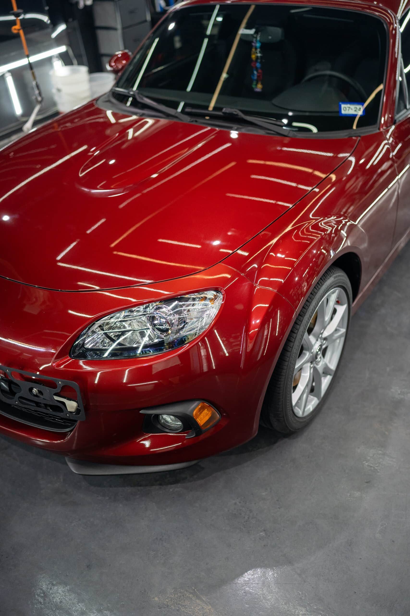 A red sports car is parked in a garage
