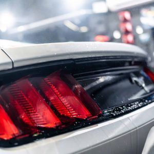 A close up of a white car with red tail lights.
