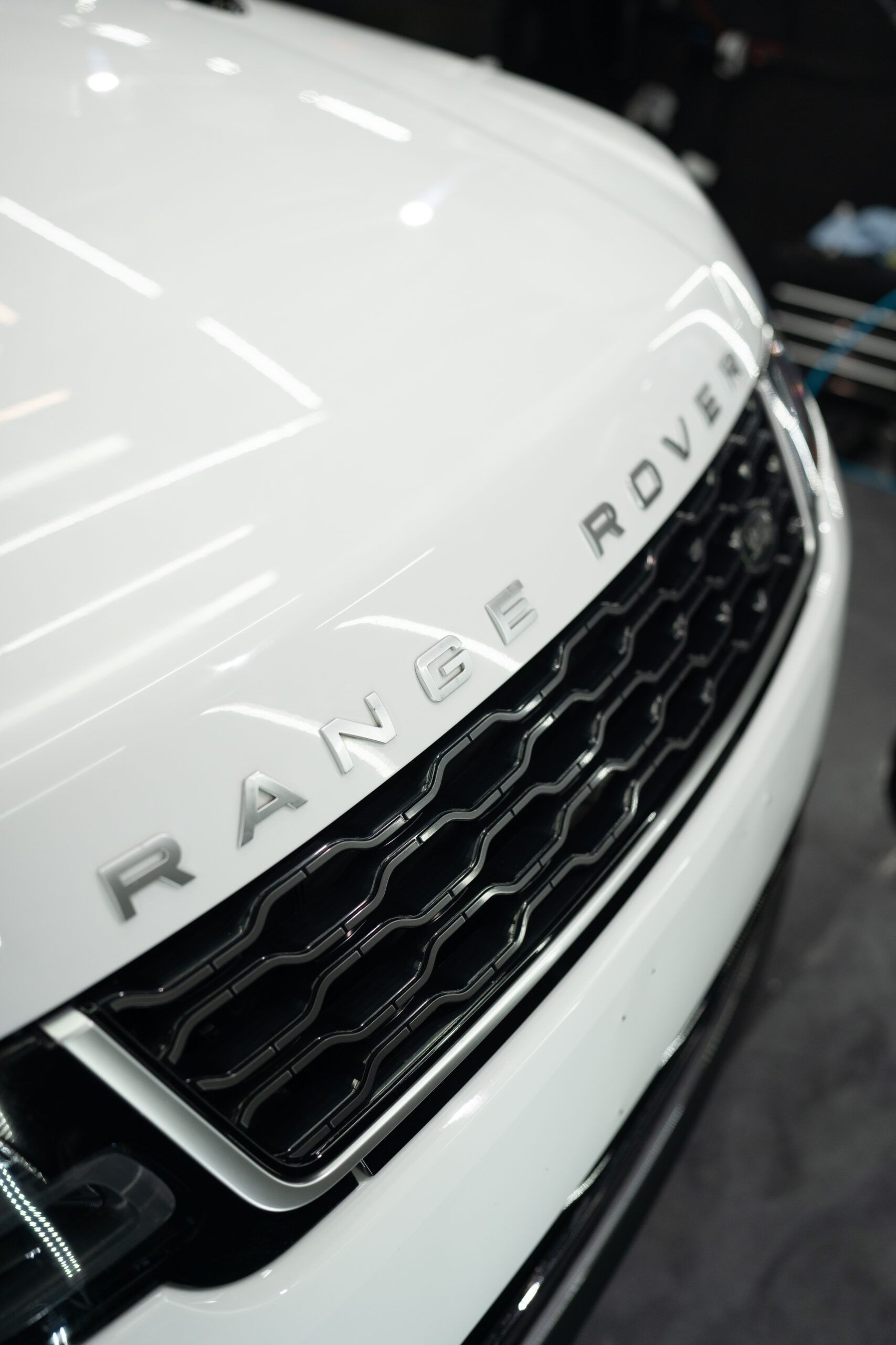 A white range rover is parked in a garage