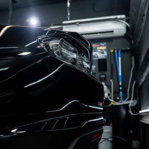 A close up of a black car in a garage.