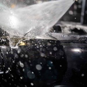 A close up of a car being sprayed with water.