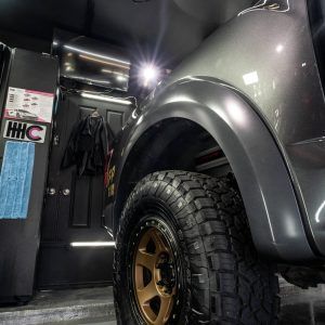 A truck is parked in a garage next to a door.