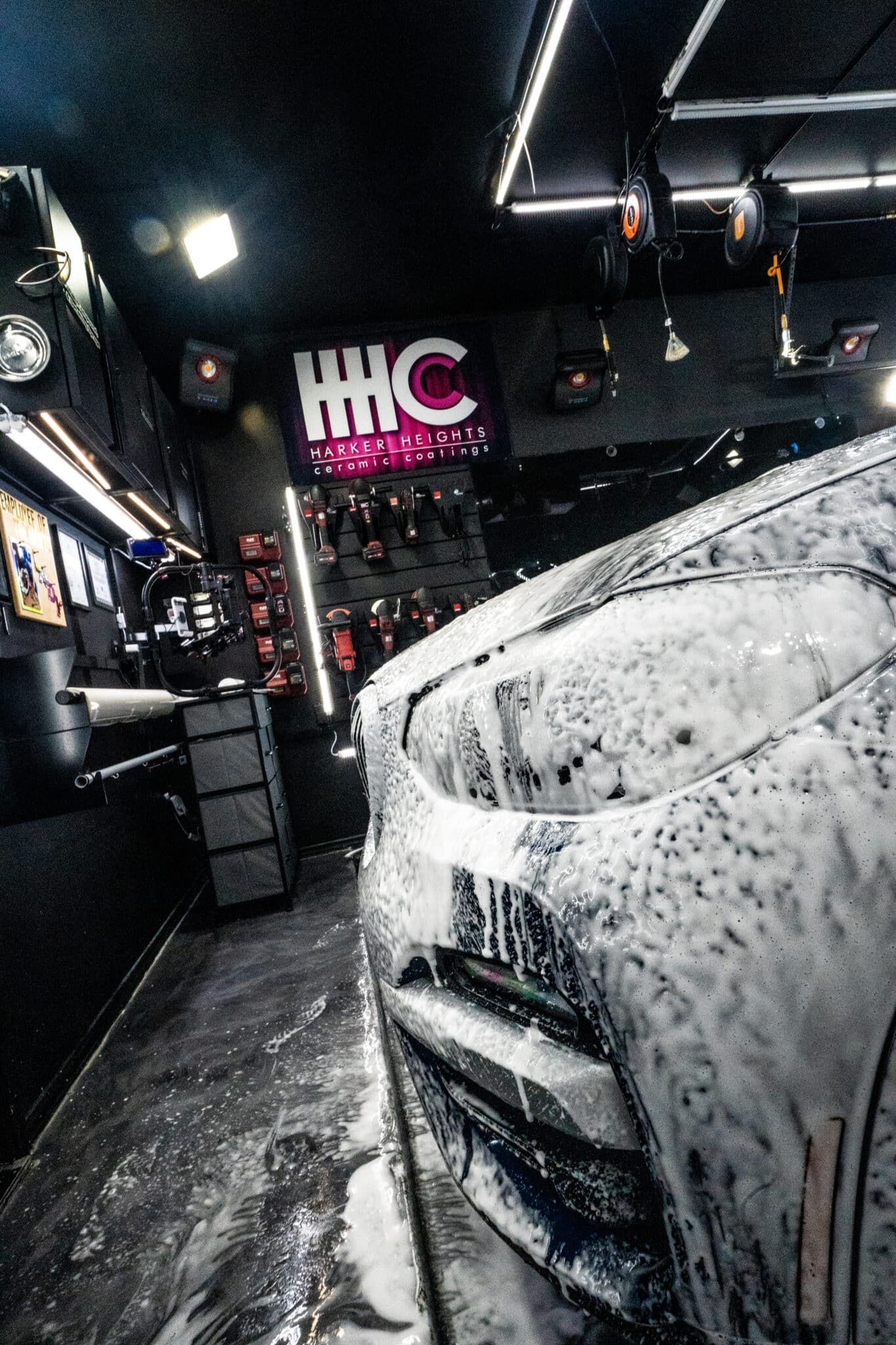 A car is covered in foam in a garage.