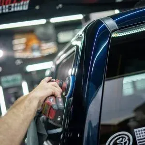 A person is polishing a car with a machine.