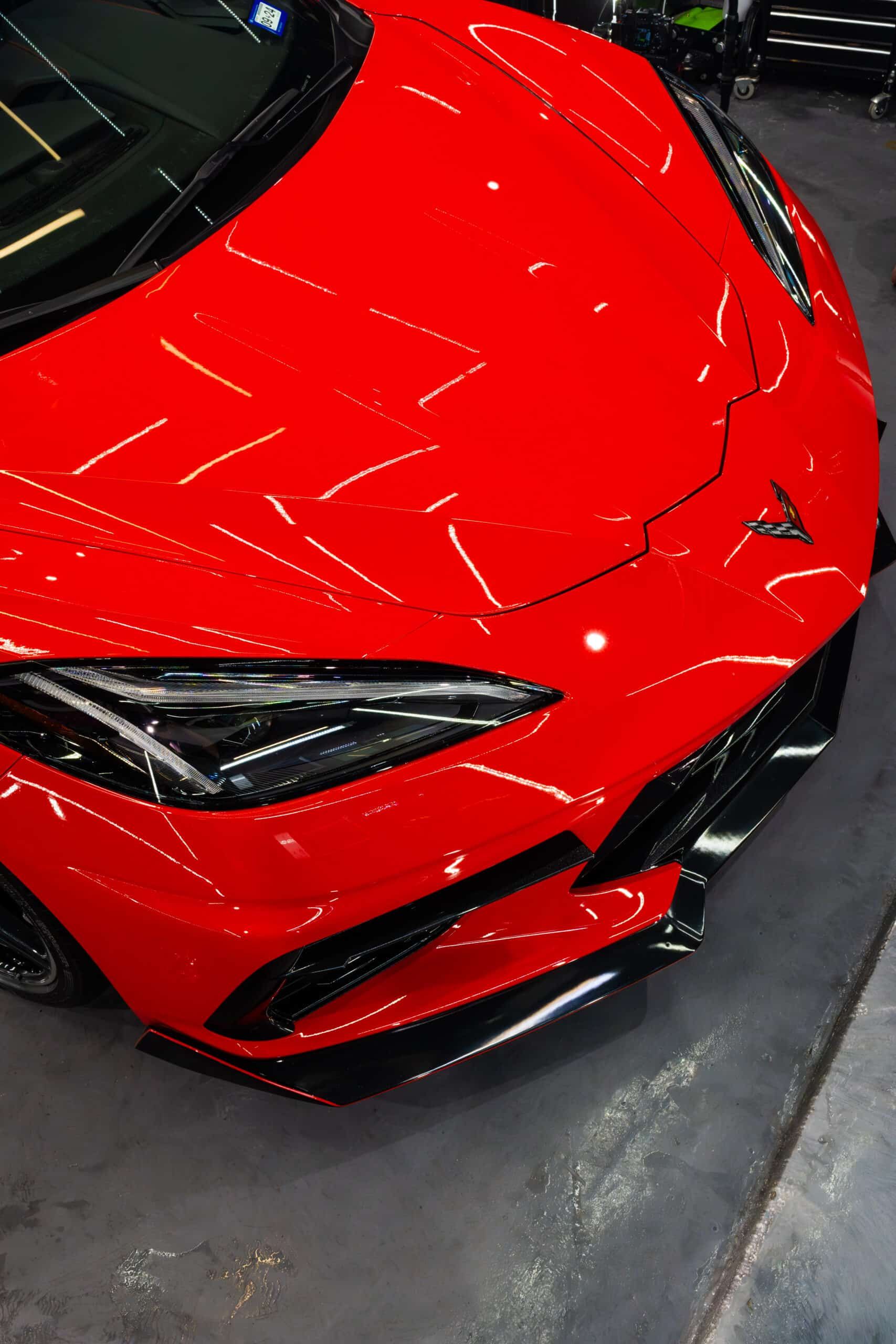 A red sports car is parked in a garage.