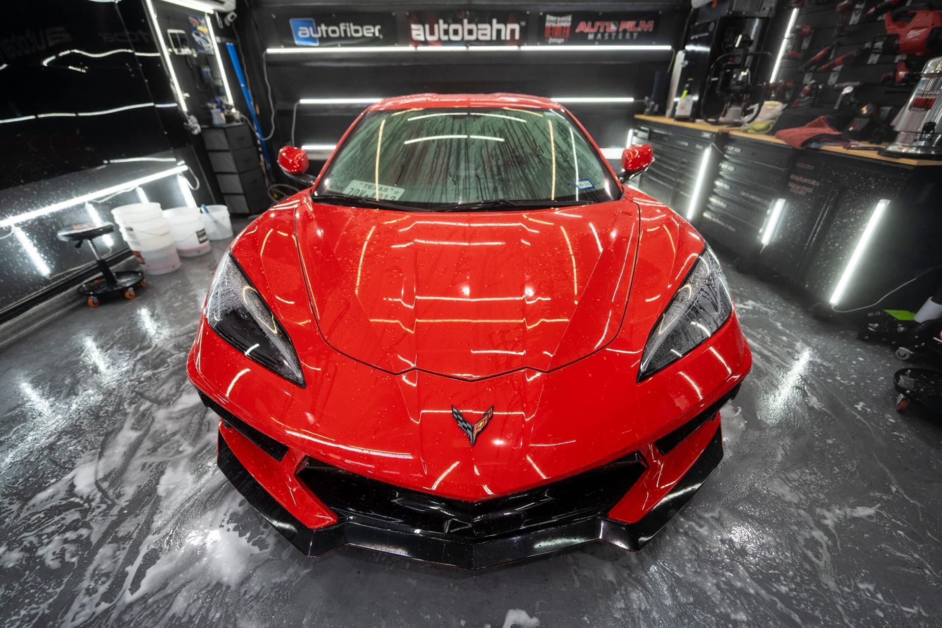 A red sports car is parked in a garage.