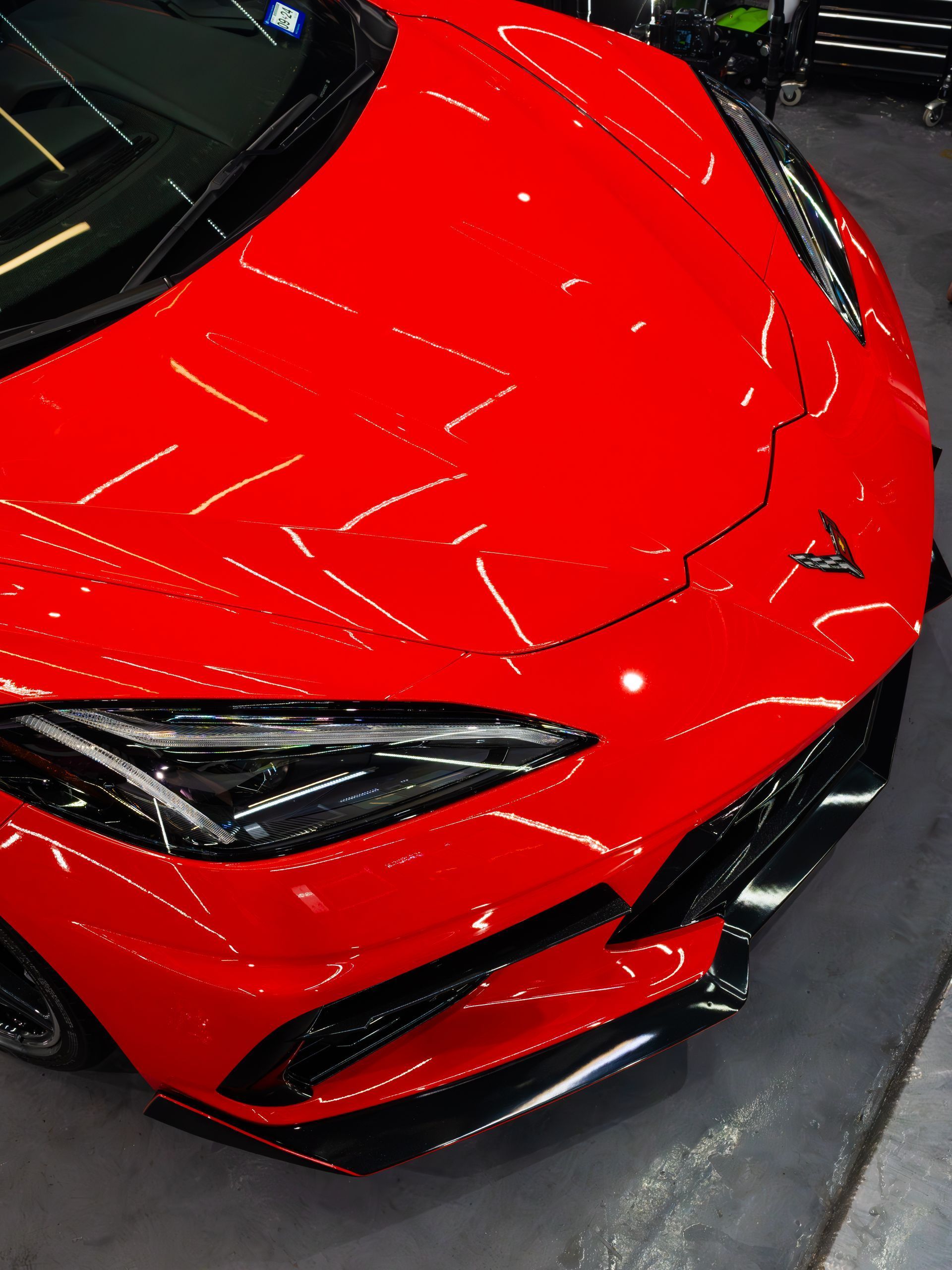 A red sports car is parked in a garage