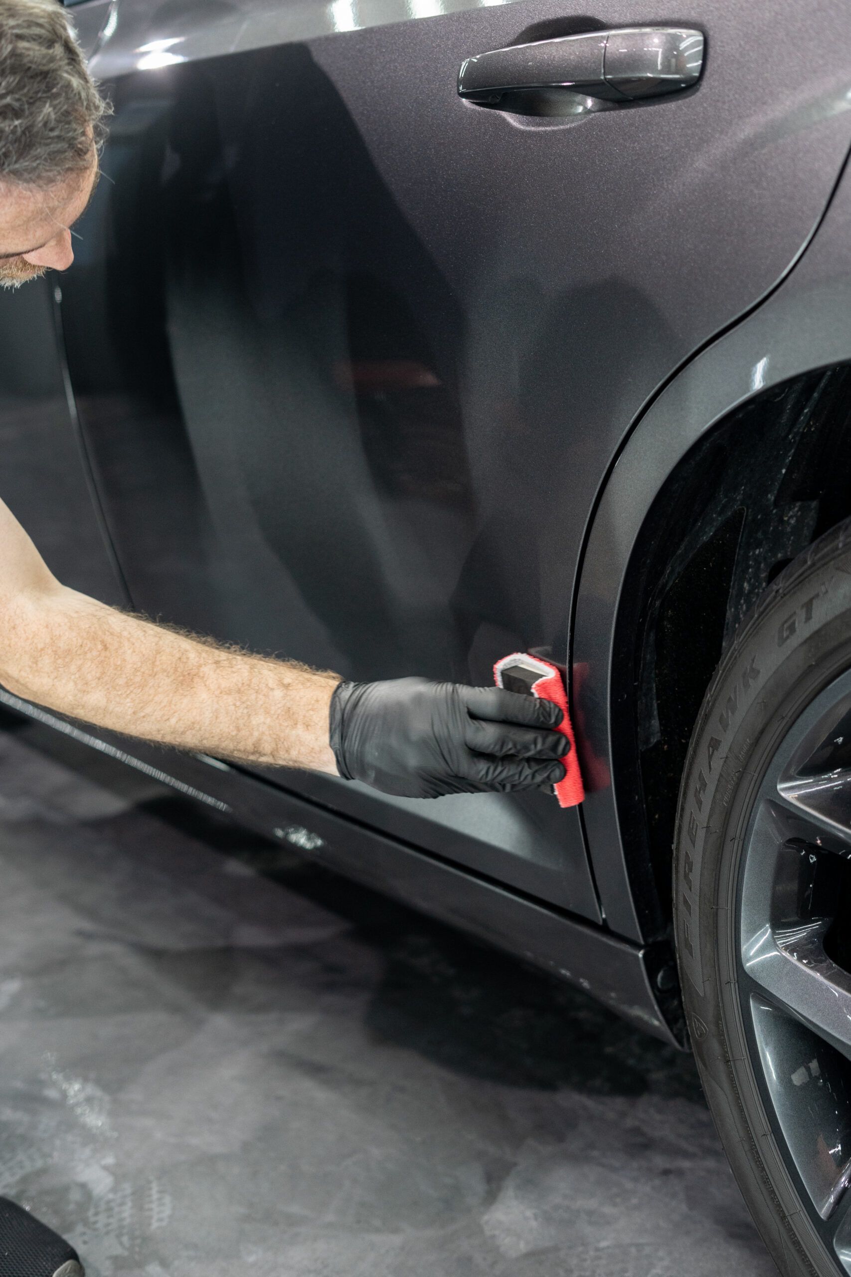 A man is polishing the side of a car.