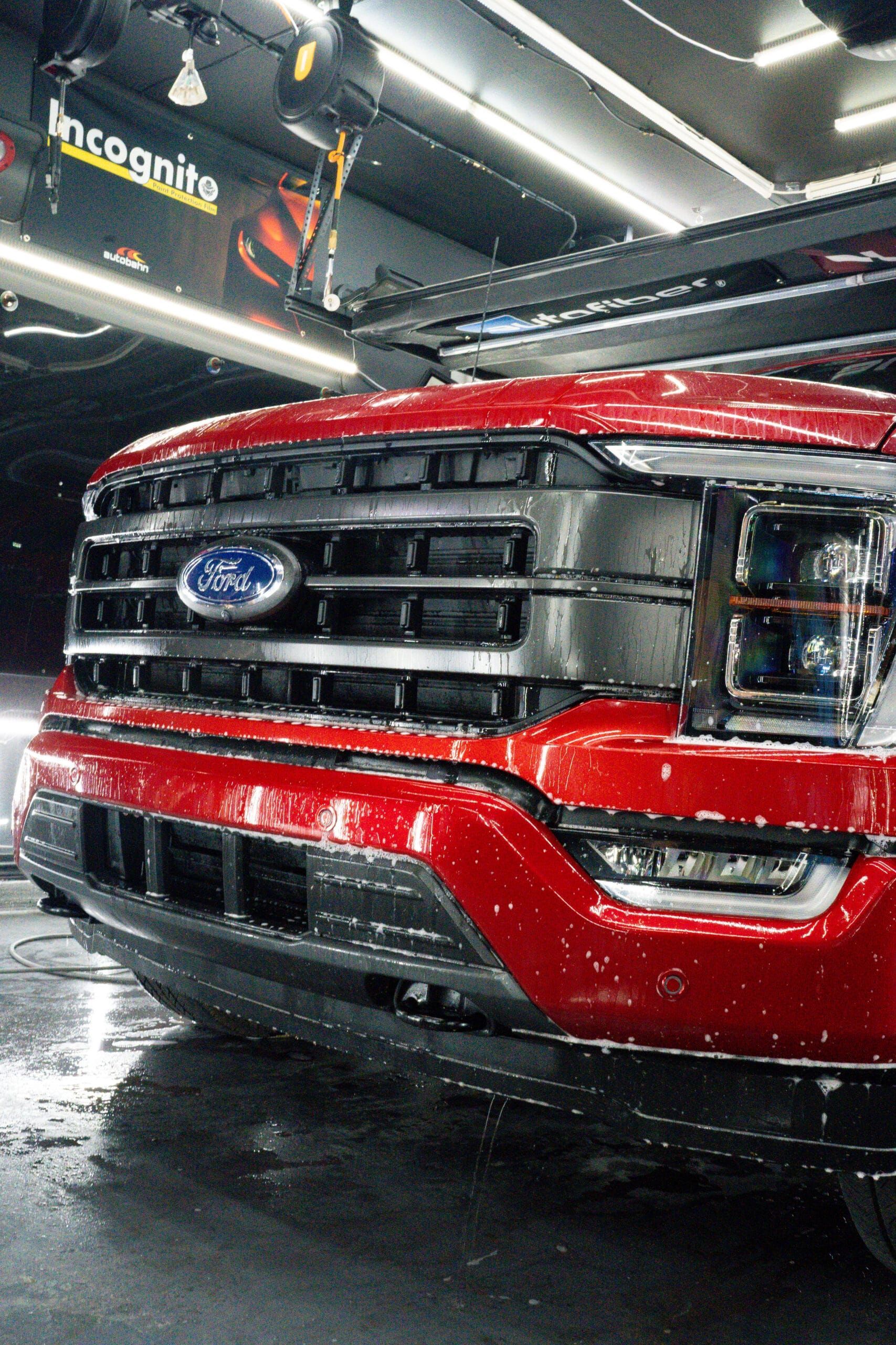 A red ford truck is parked in a garage.