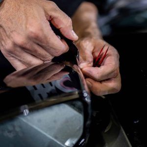 A person is cutting a piece of tape with a pair of scissors.