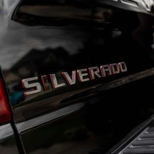 The back of a black silverado truck with the word silverado on it.