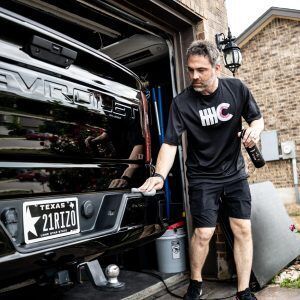 A man is standing next to a truck in a garage.