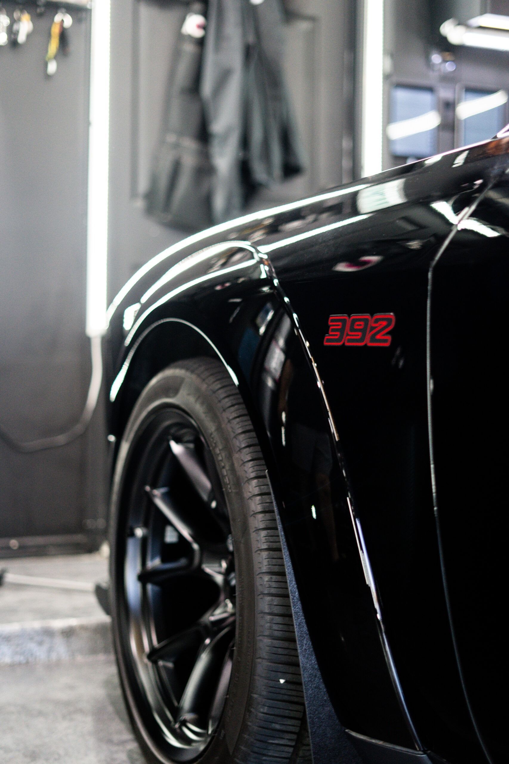 A close up of a black car with a red emblem on the side