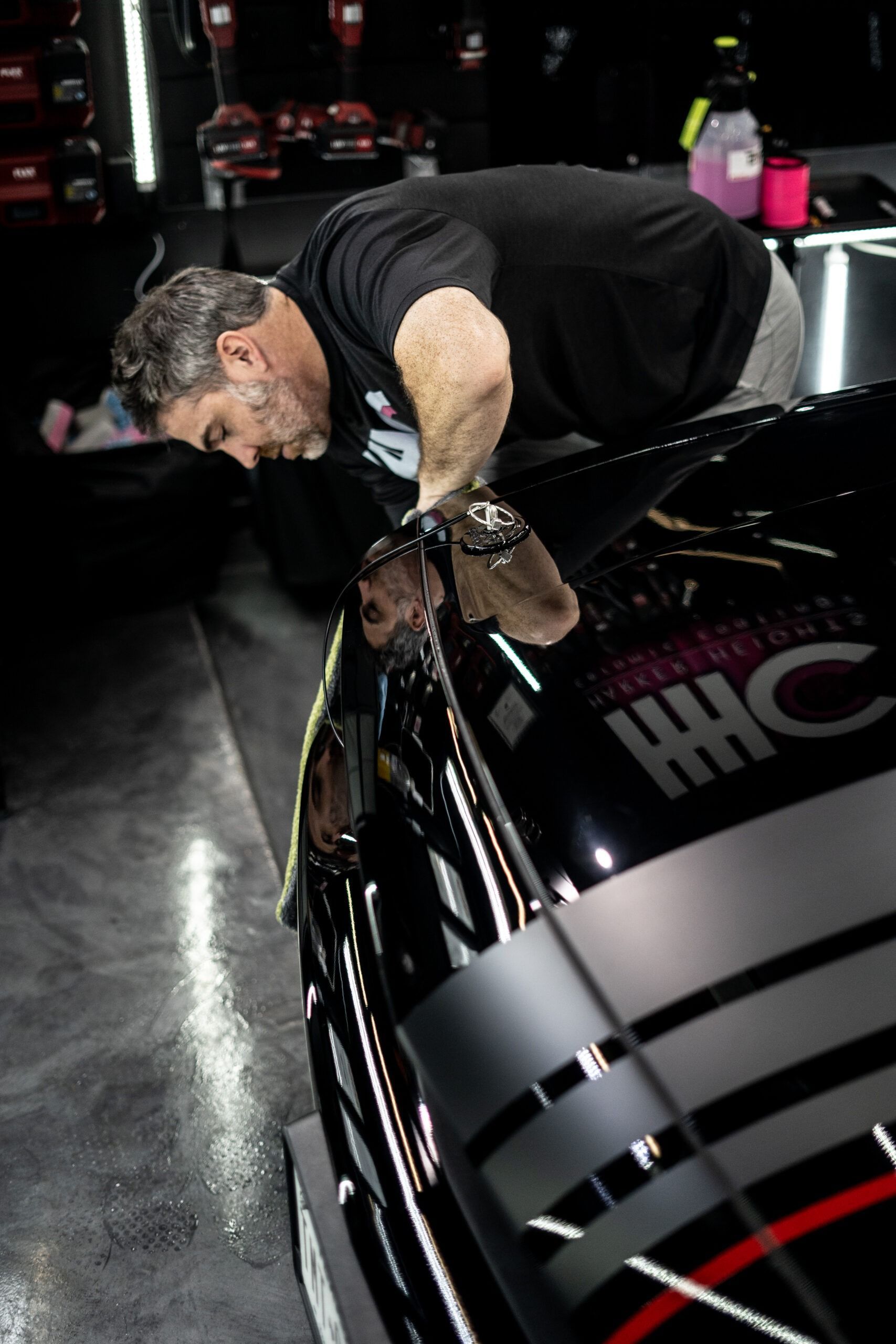 A man is working on a car that says hhc on it