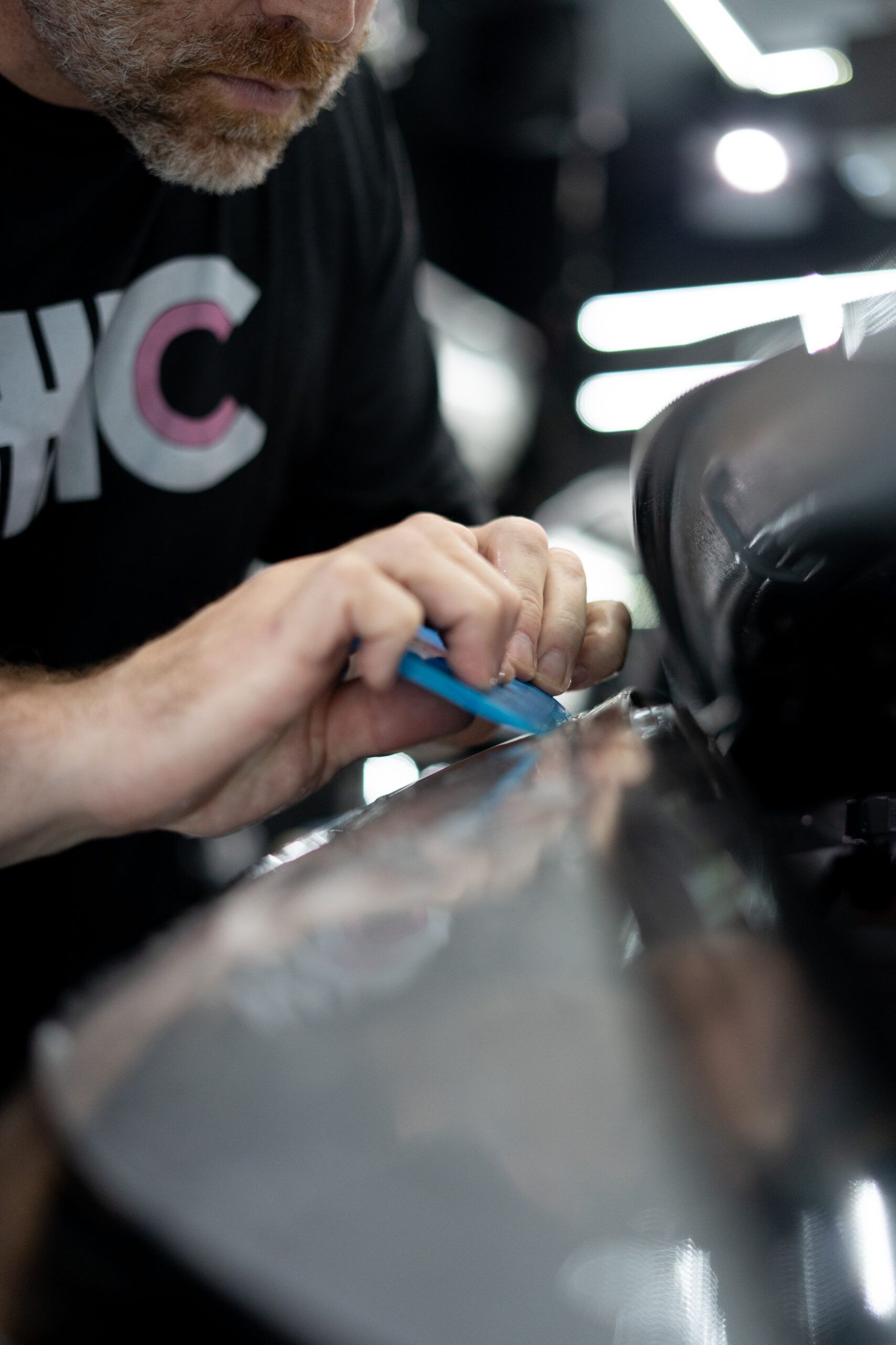 A man in a black shirt is working on a car.