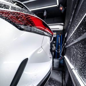 A white car is sitting in a garage next to a wall.