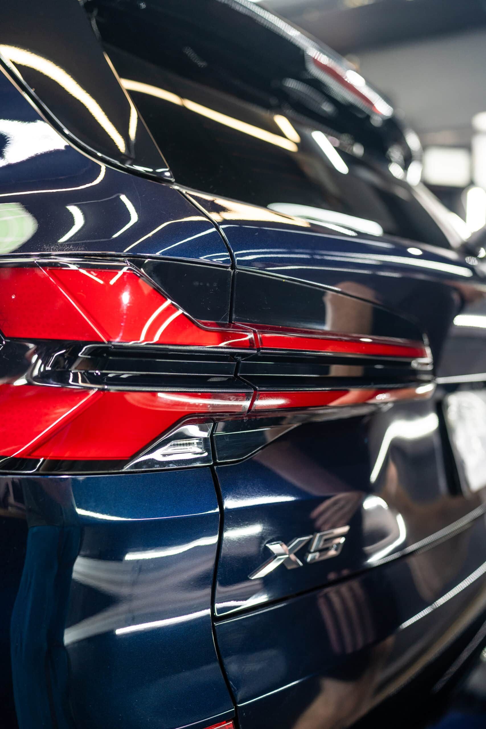 A close up of a blue and red car in a garage