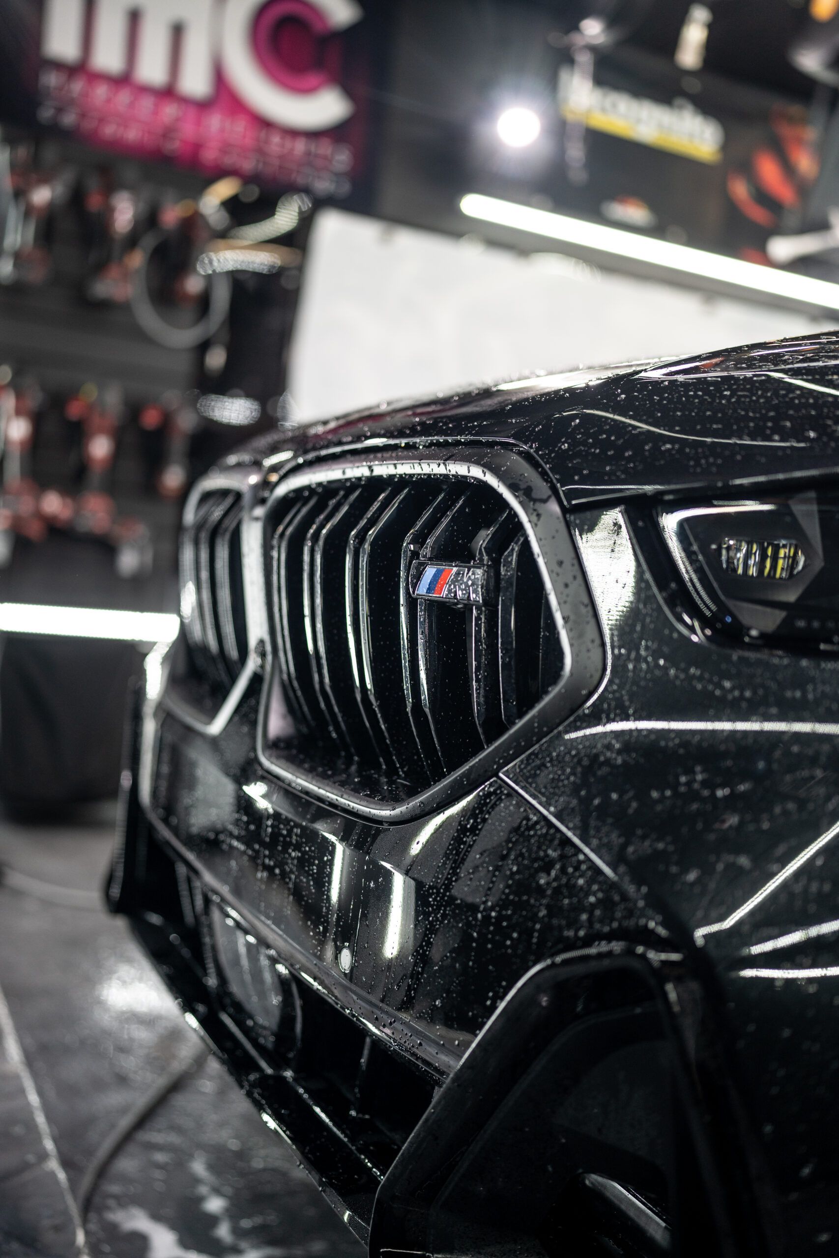 A black bmw x5 is being washed in a car wash.