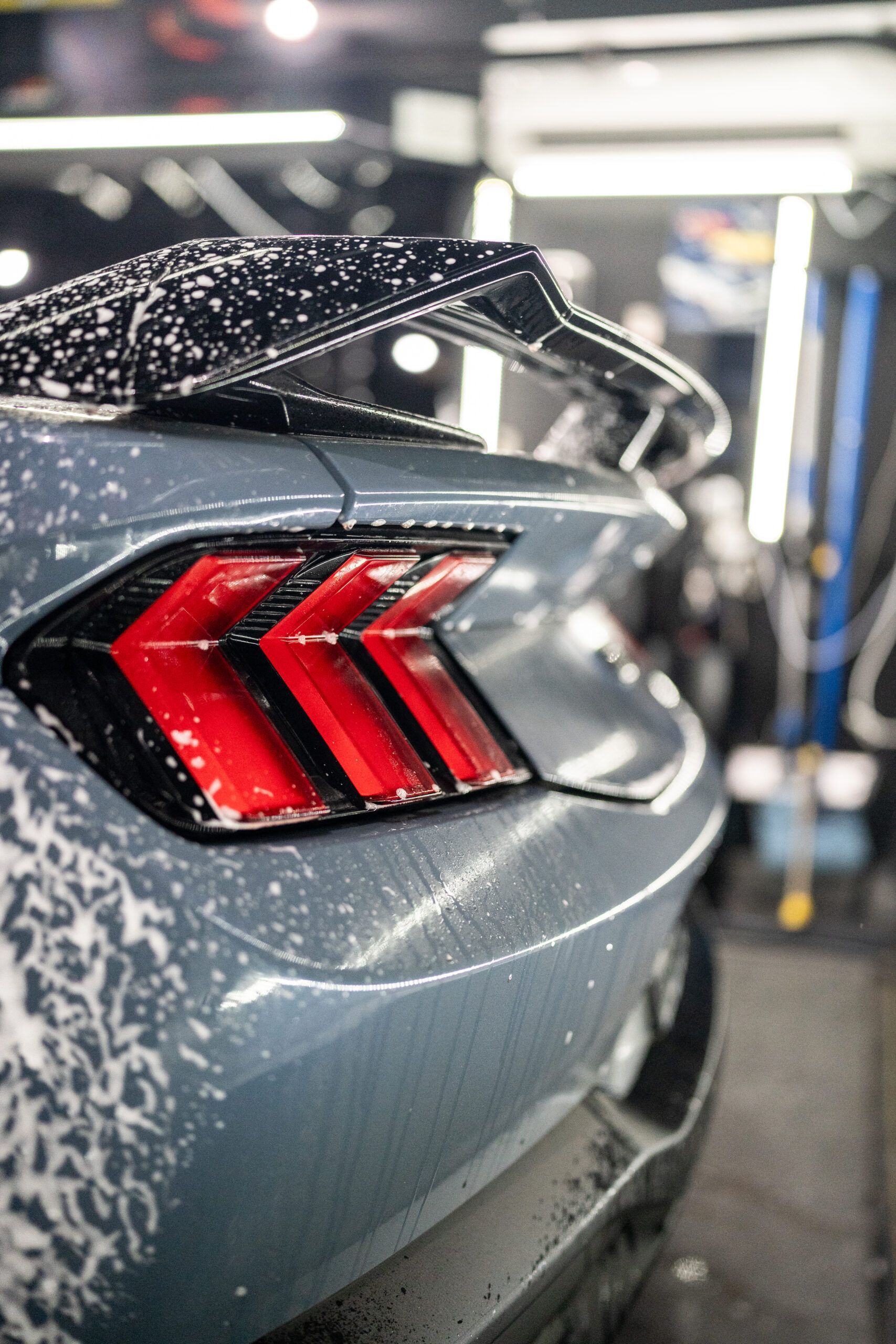 A close up of a car 's tail light in a garage.