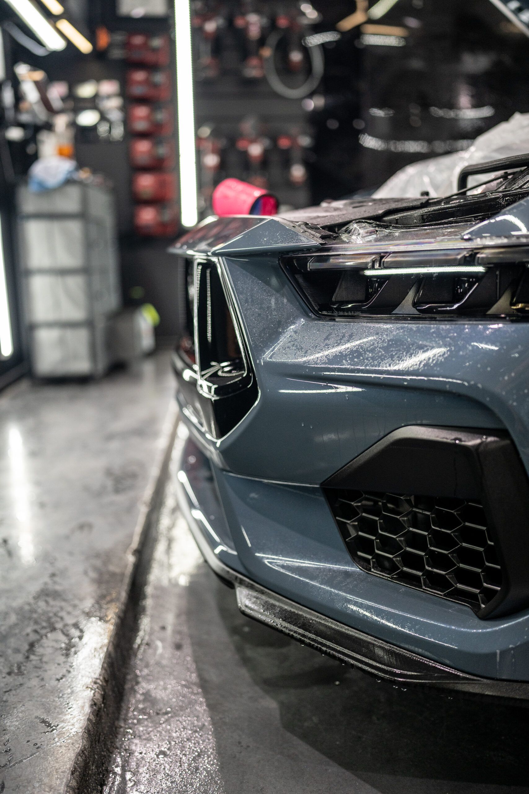 A close up of the front of a car in a garage.