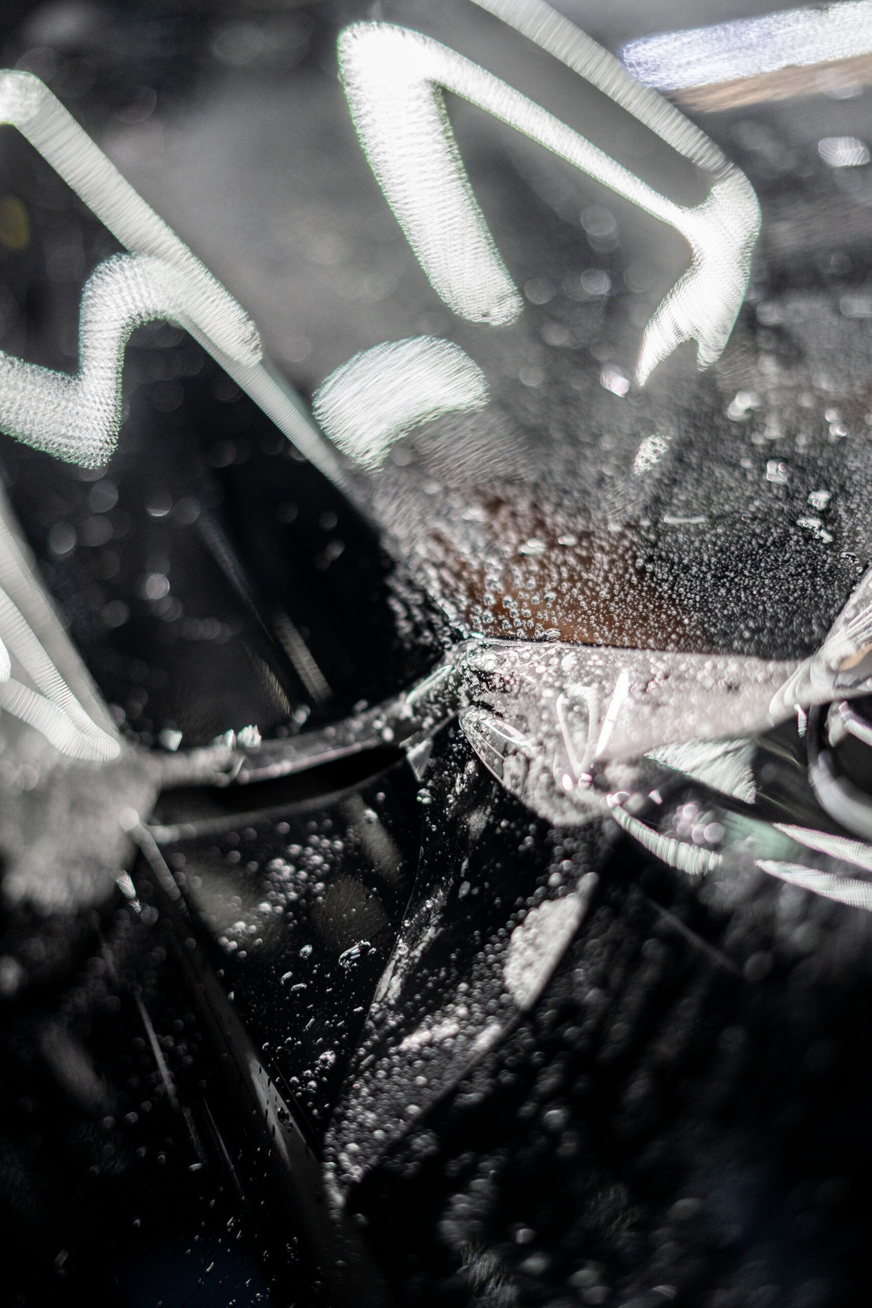 A close up of a person cleaning a car wheel with a brush.