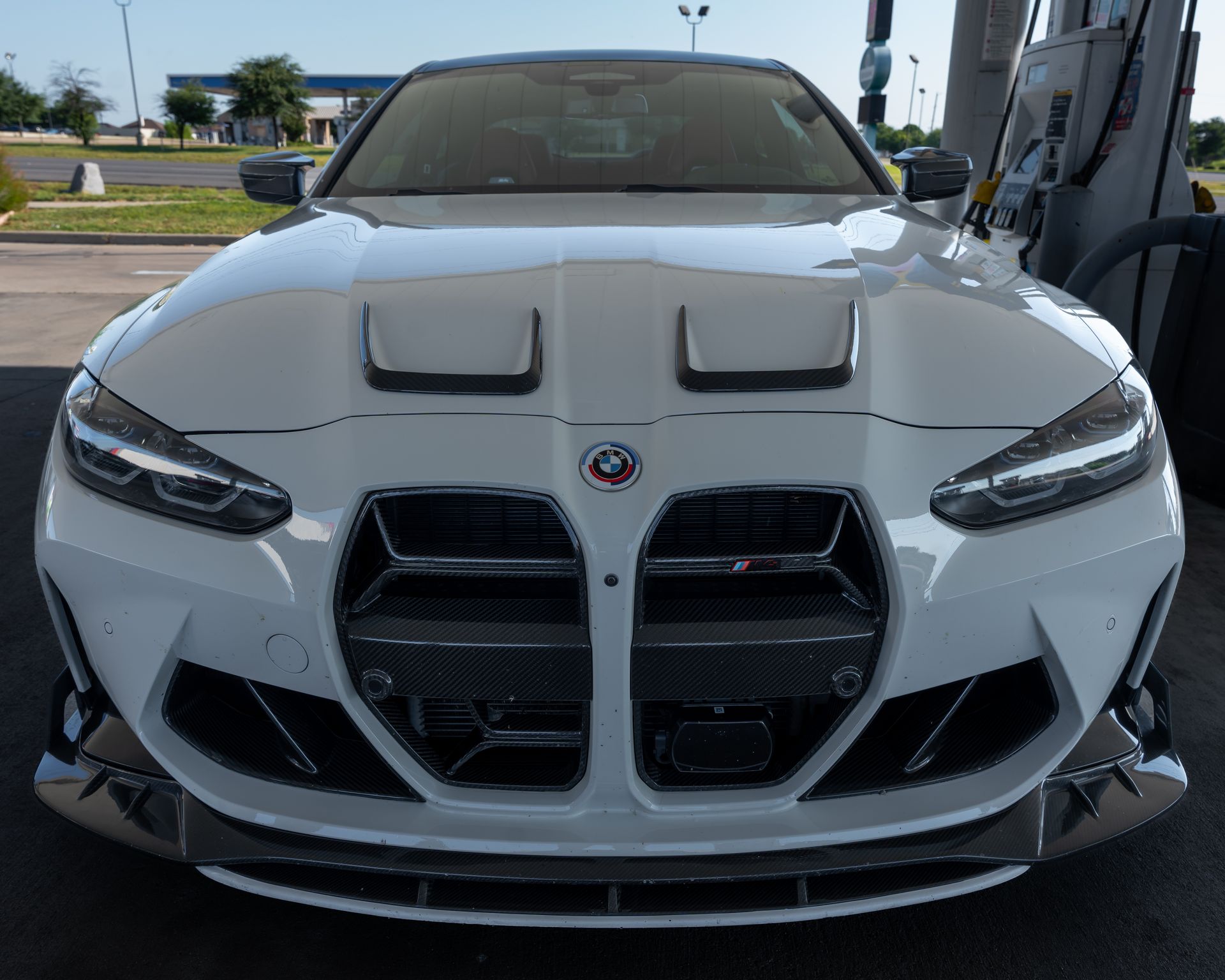 A white sports car is parked in a garage.