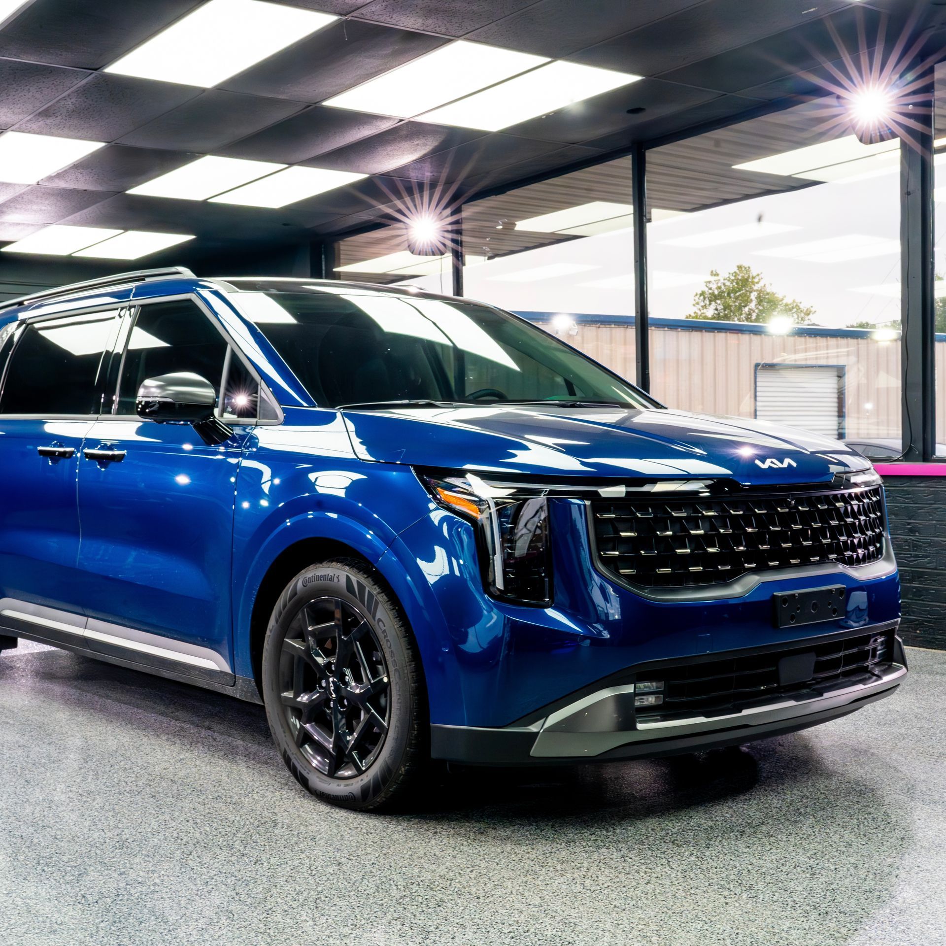 A man is wrapping a car in blue color change ppf.