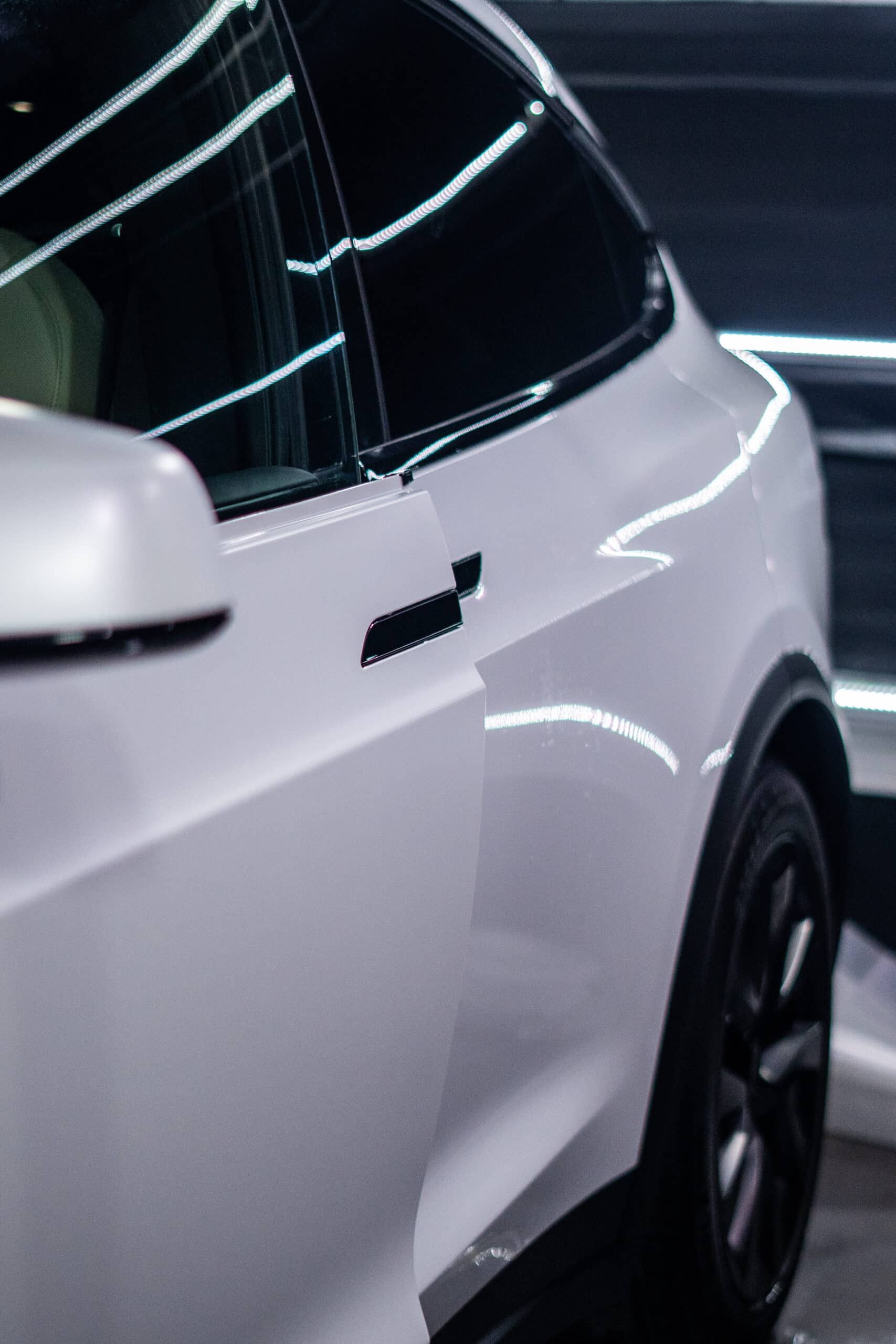A close up of a white car with black wheels