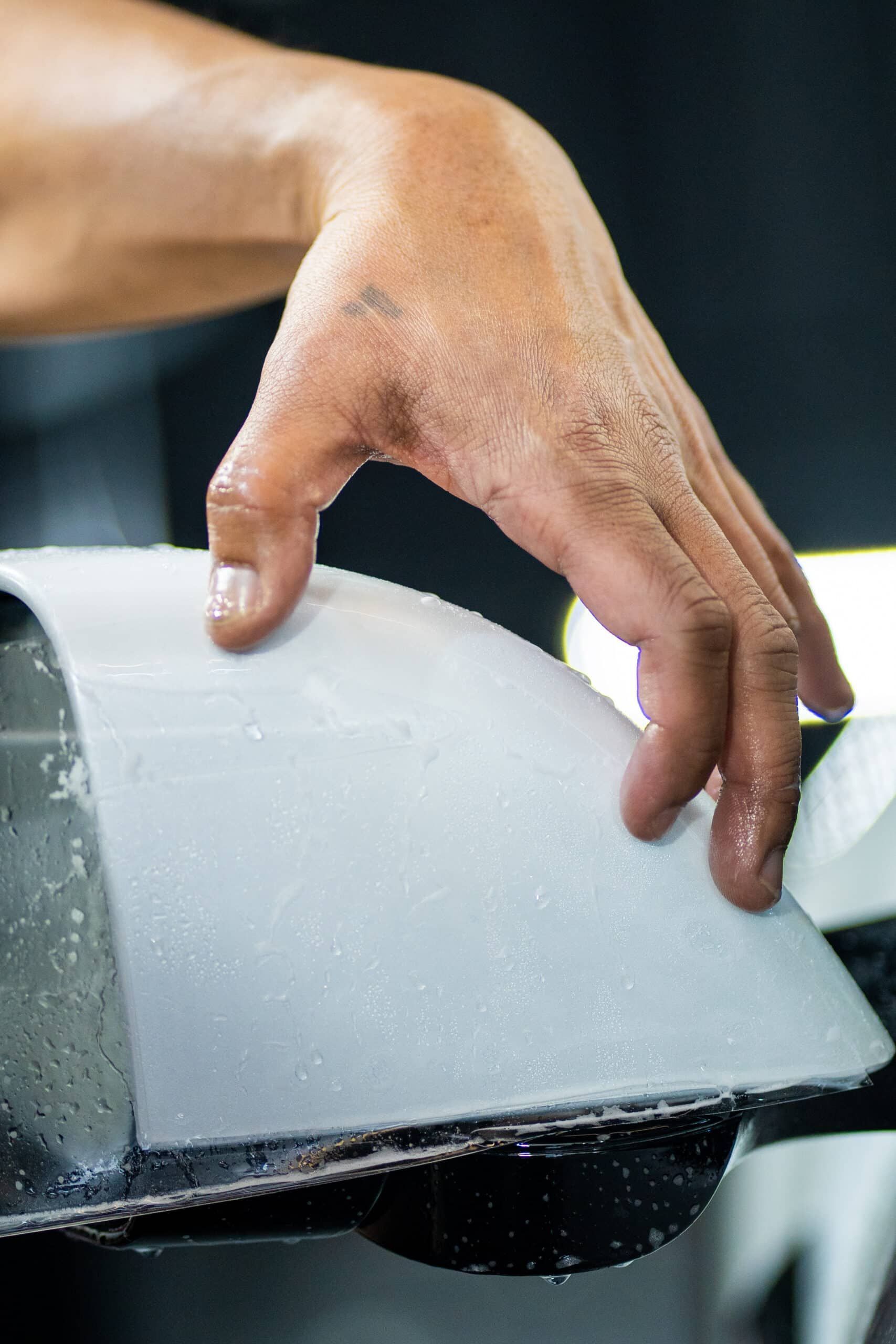 A person is cutting a piece of metal with a saw.