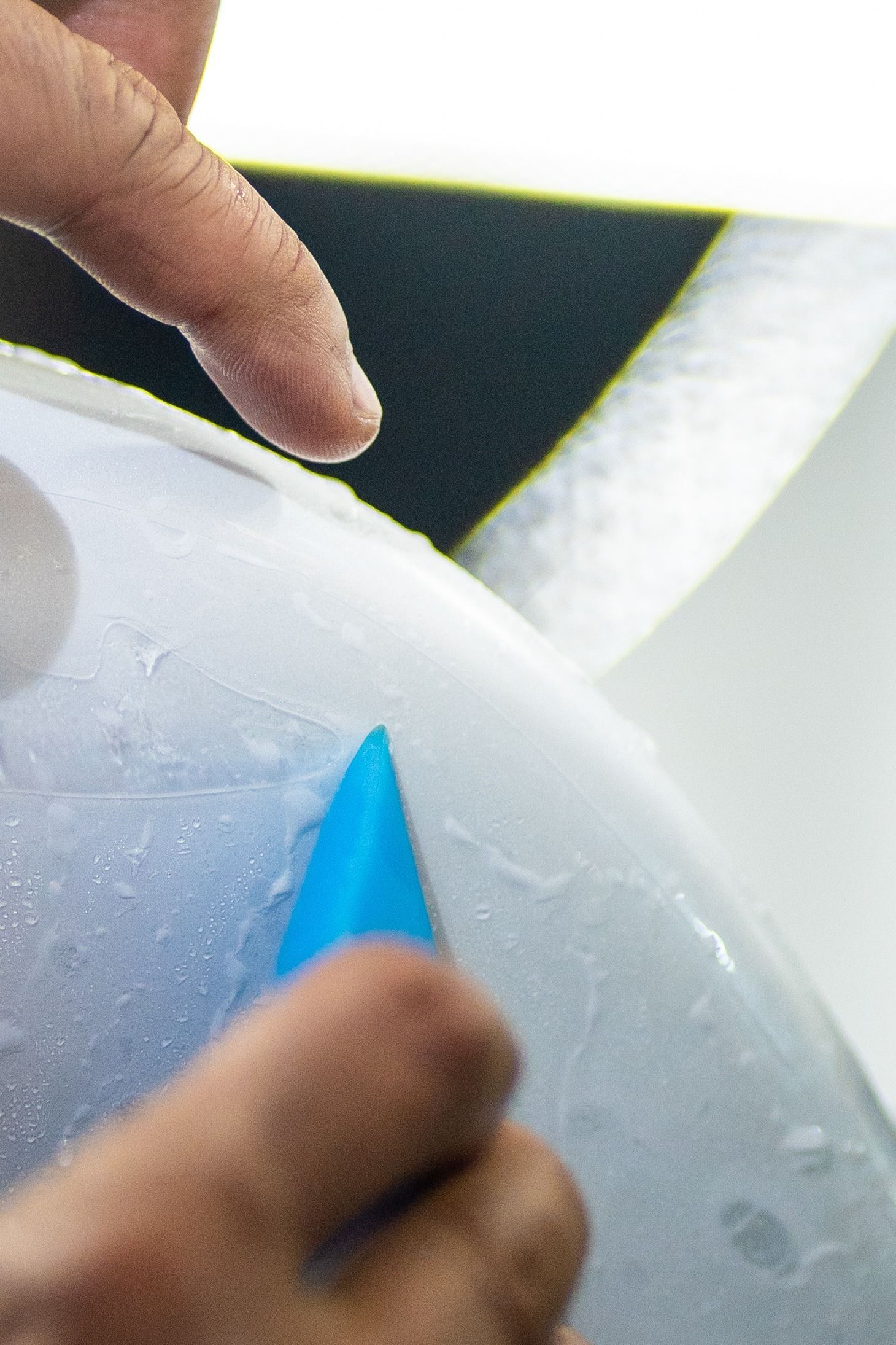 A person is holding a blue triangle in their hand.