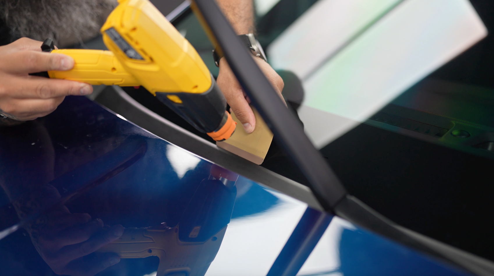 A man is installing window tint on a vehicle.