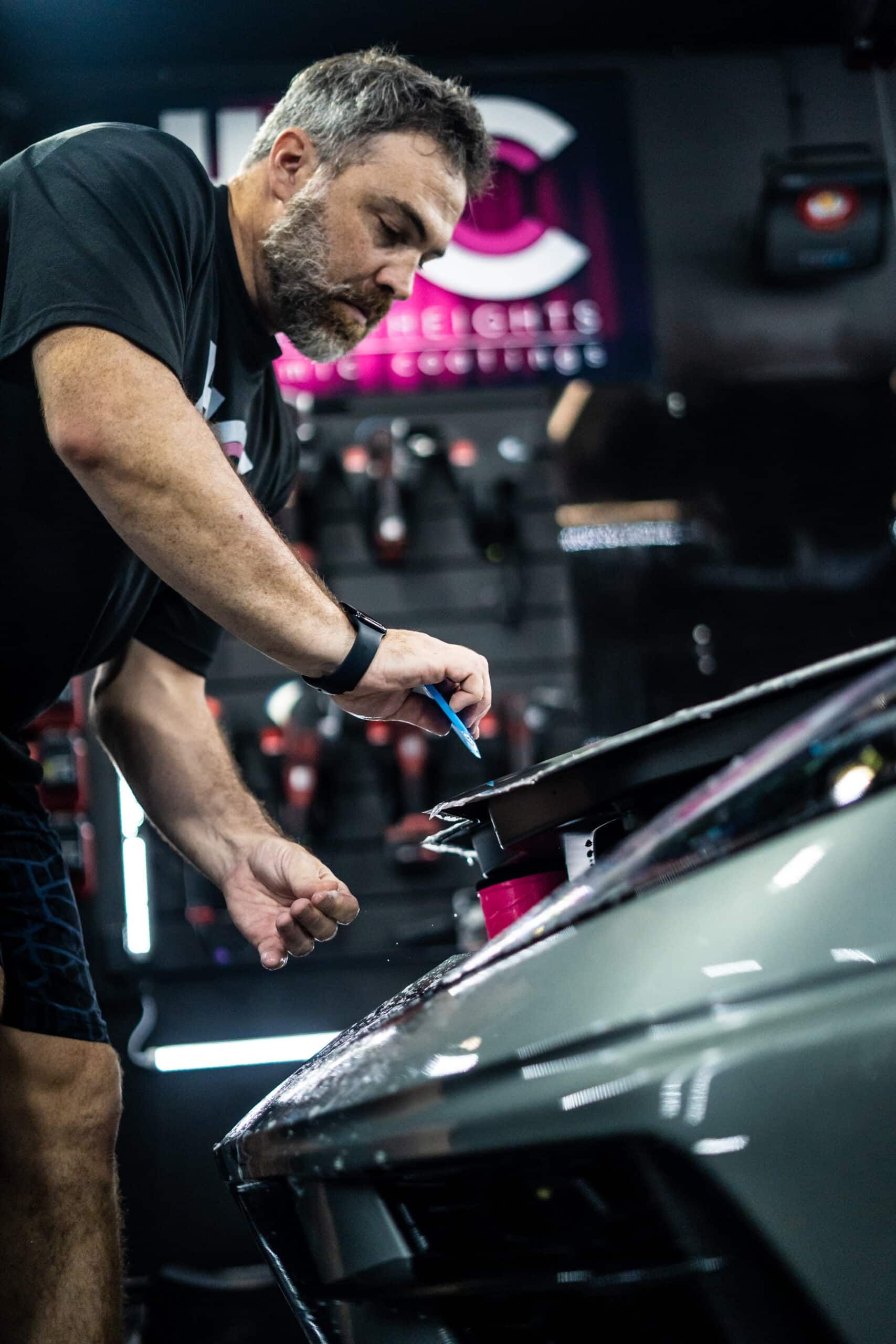 A man is working on a car in a garage.
