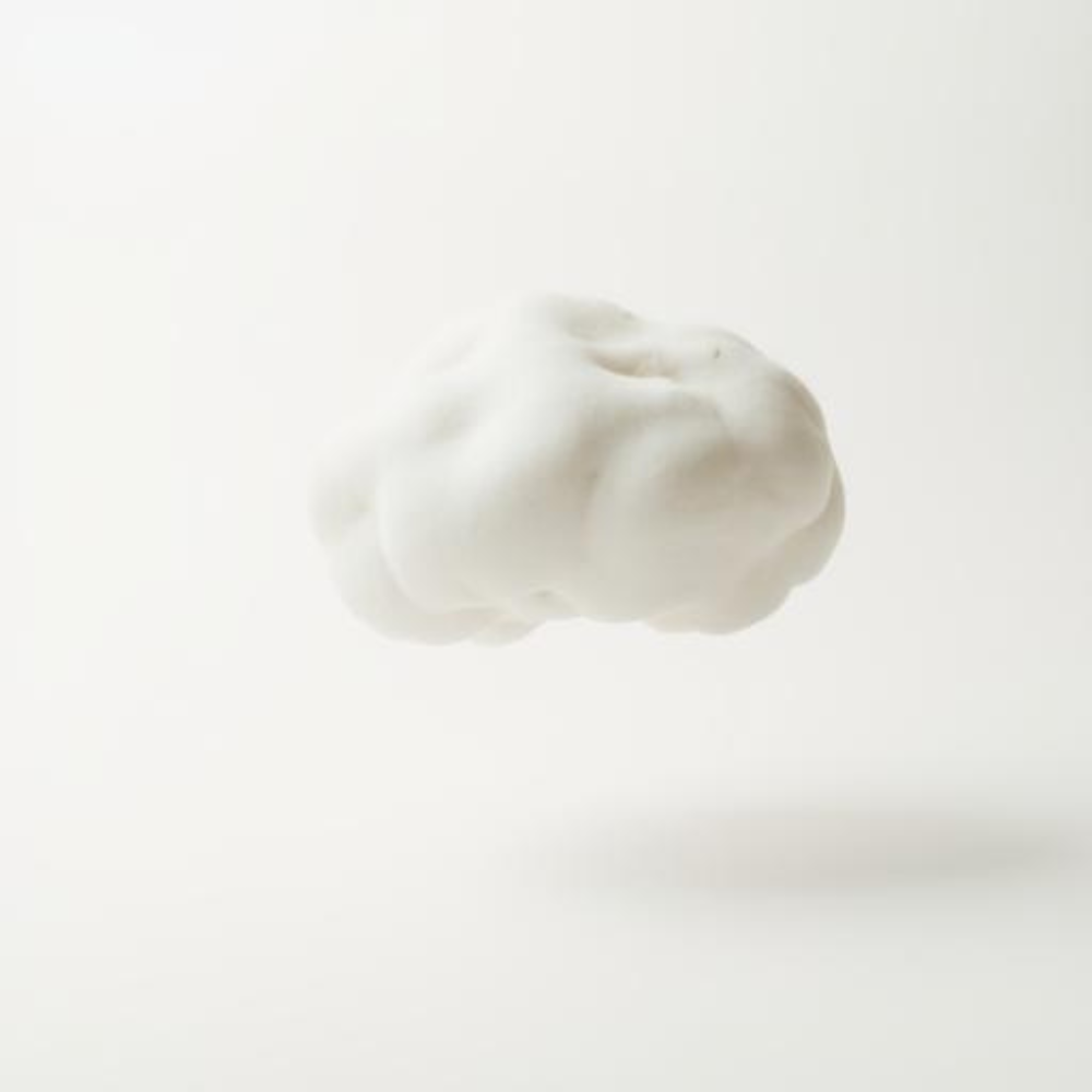 Weiße, flauschige Wolke schwebt vor einem einfarbigen, hellen Hintergrund